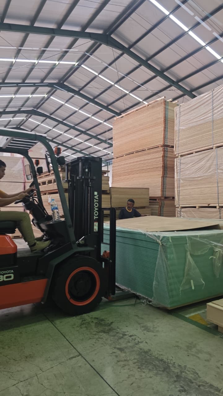 Tumpukan papan kayu olahan siap distribusi